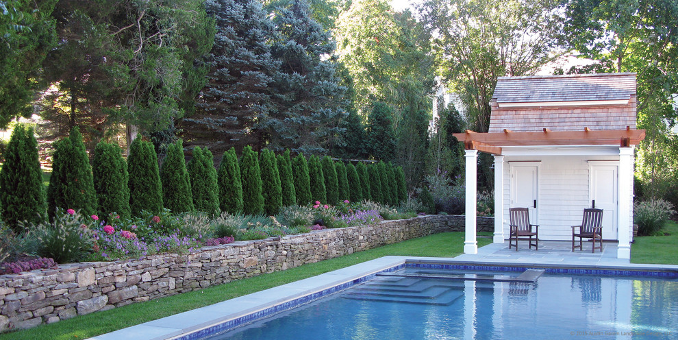 Bild på en mellanstor vintage rektangulär pool längs med huset, med poolhus och naturstensplattor
