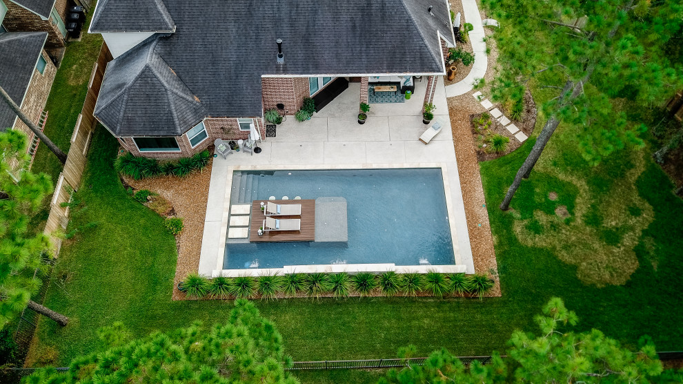 Пример оригинального дизайна: большой прямоугольный бассейн на заднем дворе в стиле ретро с настилом