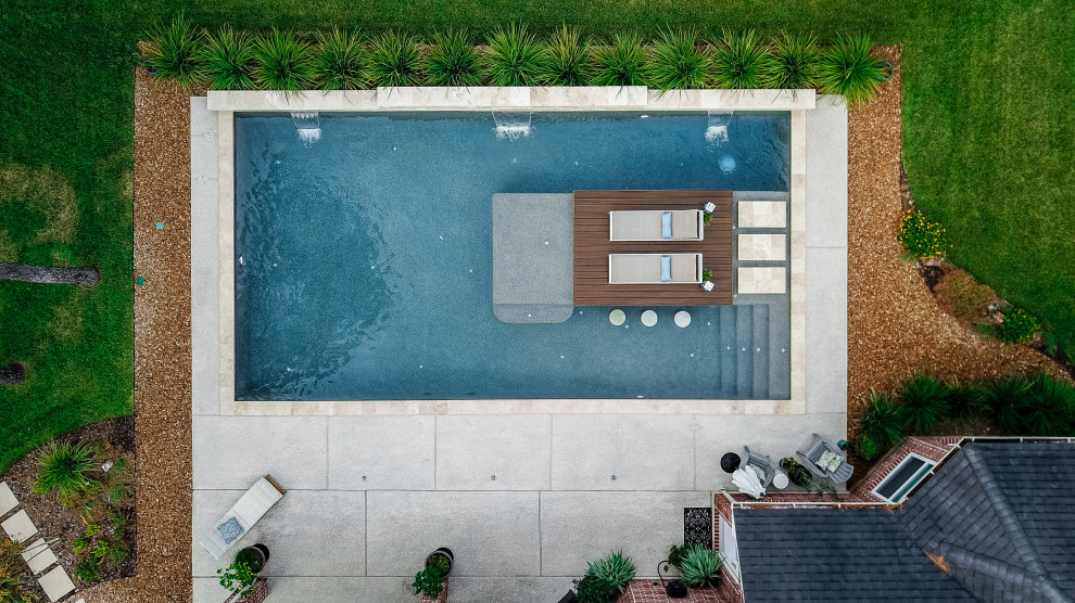 Idée de décoration pour une grande piscine arrière vintage rectangle avec une terrasse en bois.