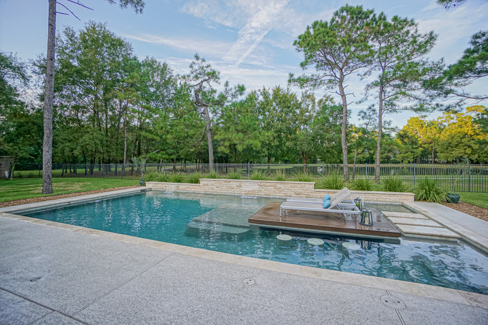 Large 1960s backyard rectangular pool photo in Houston with decking