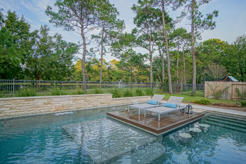 Immagine di una grande piscina moderna rettangolare dietro casa con pedane