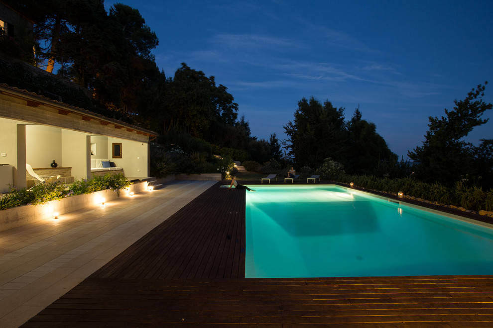 Ispirazione per una grande piscina mediterranea a "L" davanti casa con una dépendance a bordo piscina e pedane