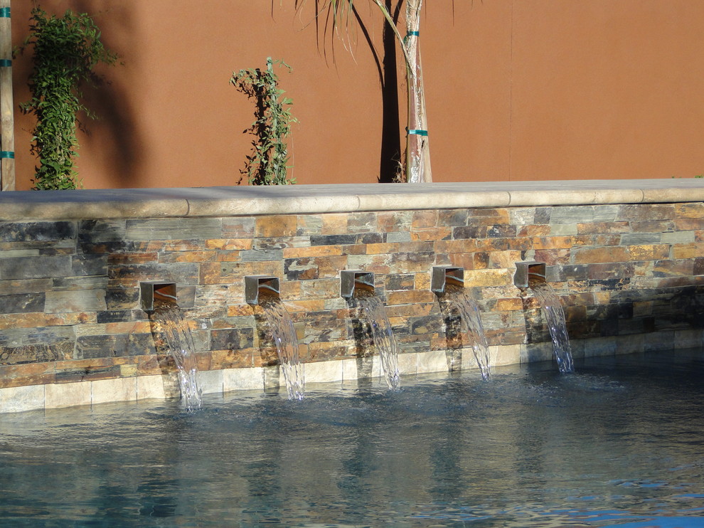 Diseño de piscina con fuente alargada clásica en forma de L en patio trasero