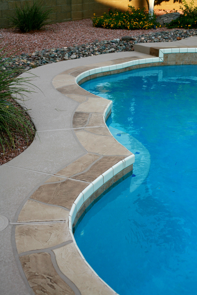 Ispirazione per una piscina naturale classica personalizzata dietro casa con cemento stampato