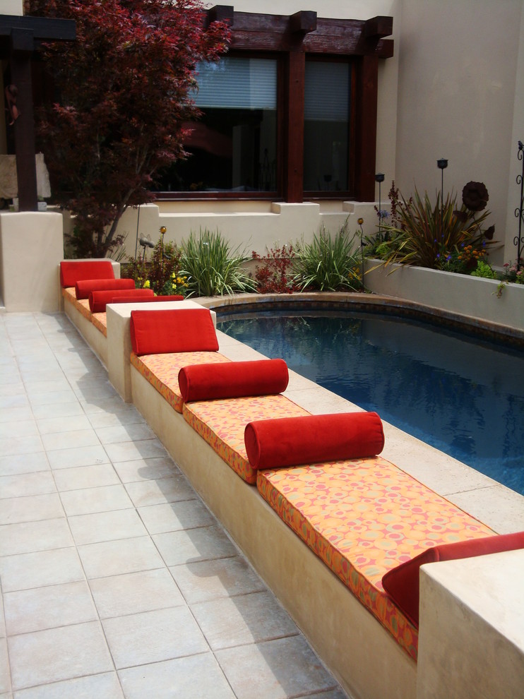 Свежая идея для дизайна: угловой бассейн среднего размера на заднем дворе в современном стиле с покрытием из каменной брусчатки - отличное фото интерьера