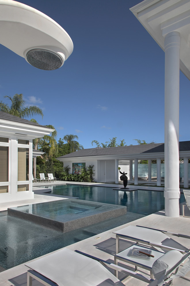 Foto de piscina alargada contemporánea extra grande rectangular en patio con adoquines de piedra natural