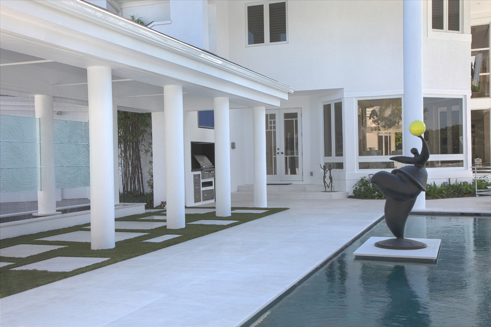 Foto de piscina alargada actual extra grande rectangular en patio con adoquines de piedra natural