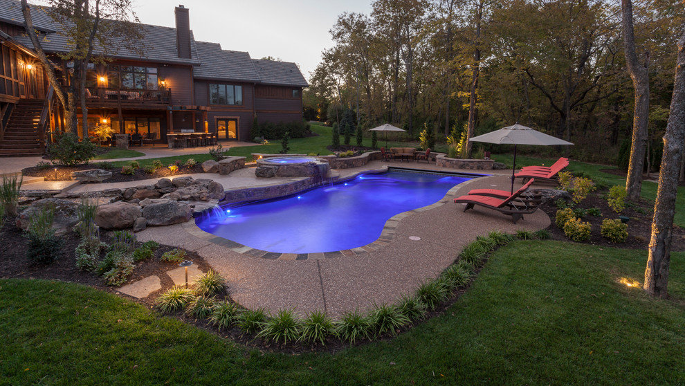 Пример оригинального дизайна: большой бассейн произвольной формы на заднем дворе в стиле кантри с джакузи и покрытием из бетонных плит