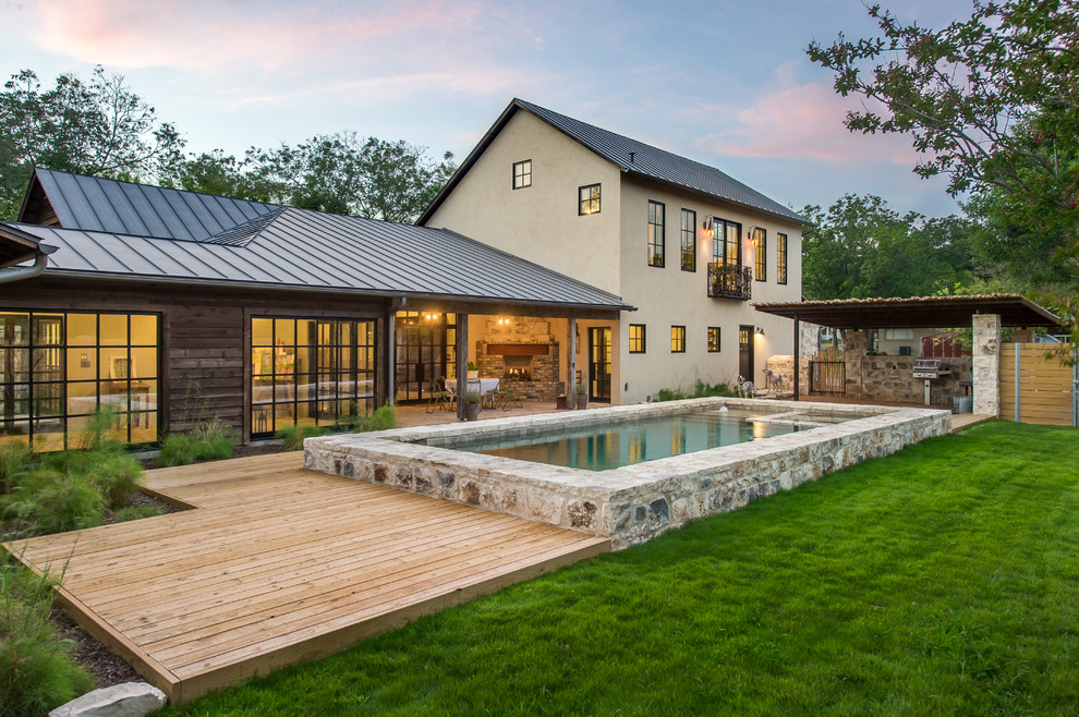 Farmhouse backyard rectangular pool photo in Austin with decking