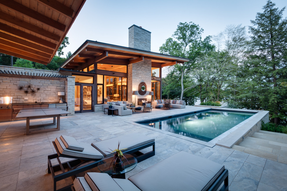 Inspiration for a huge modern backyard rectangular infinity pool remodel in Milwaukee