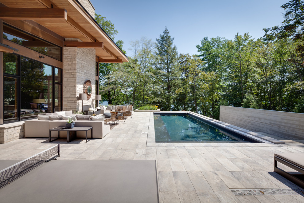 Expansive modern back rectangular lengths swimming pool in Milwaukee with a pool house.