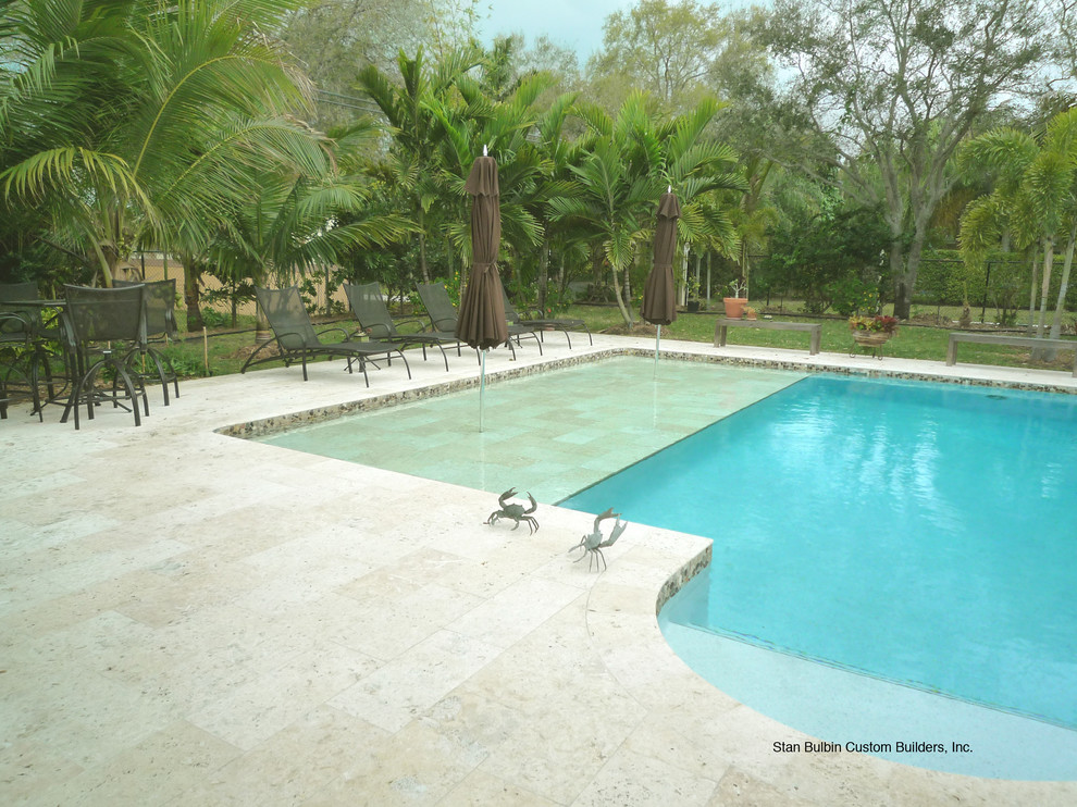 На фото: большой бассейн произвольной формы на заднем дворе в морском стиле с покрытием из плитки с