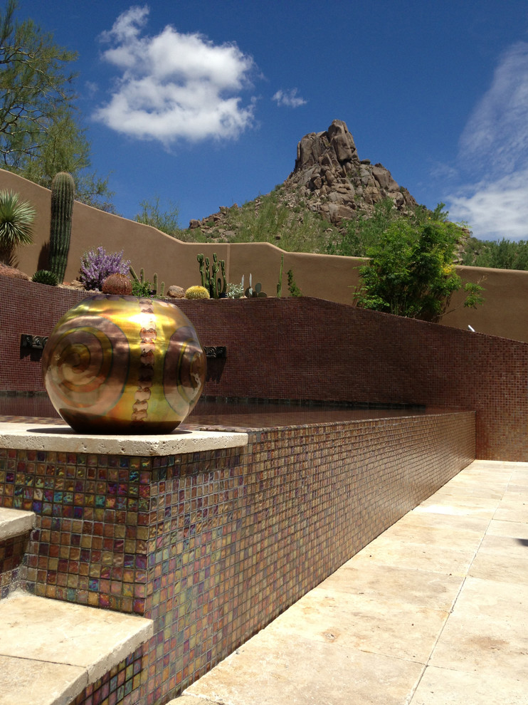 Immagine di una grande piscina a sfioro infinito contemporanea personalizzata dietro casa con fontane e piastrelle