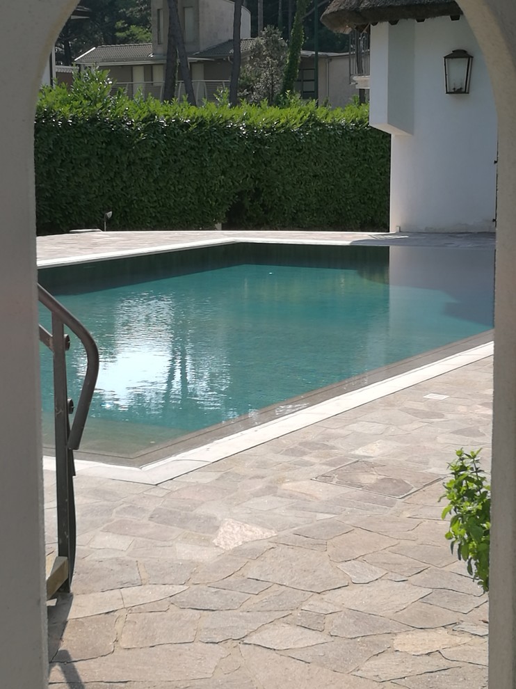Ispirazione per una grande piscina a sfioro infinito stile marino rettangolare davanti casa con piastrelle e una dépendance a bordo piscina