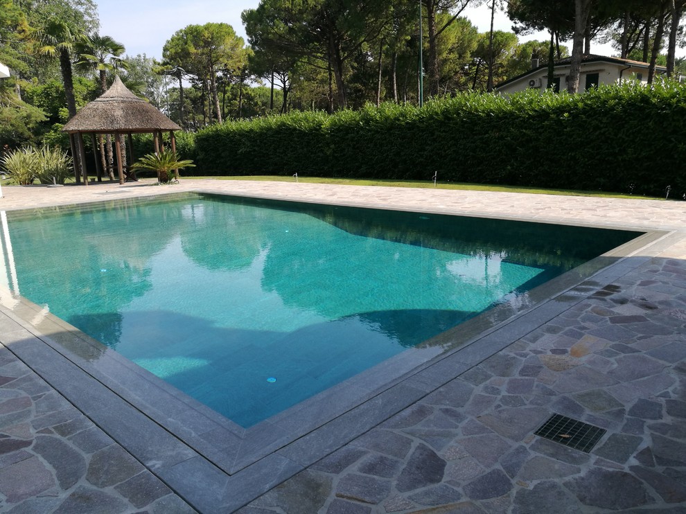 Aménagement d'un grand Abris de piscine et pool houses avant bord de mer rectangle avec du carrelage.