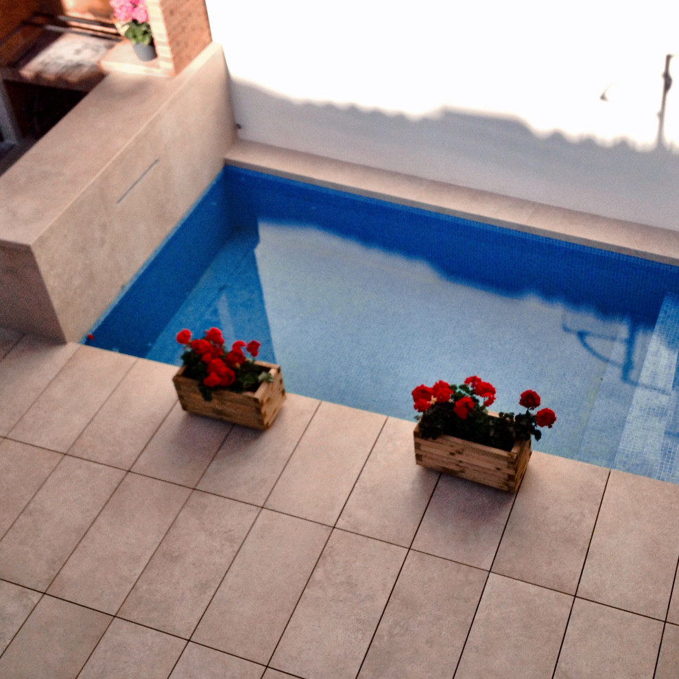 Small contemporary indoor rectangular lengths swimming pool in Alicante-Costa Blanca with a water feature and tiled flooring.
