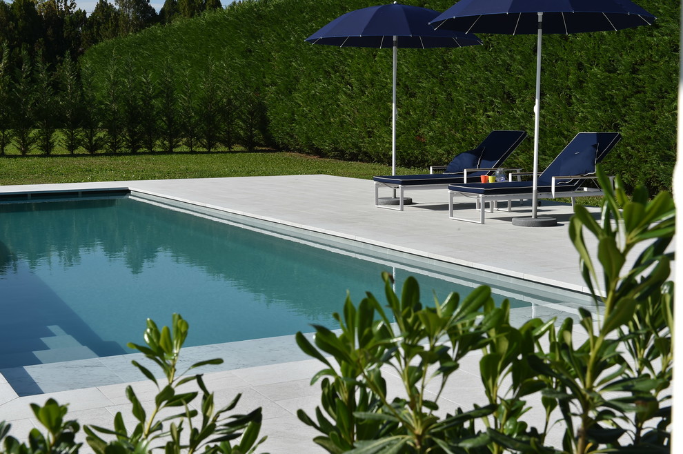 Esempio di una grande piscina fuori terra contemporanea rettangolare dietro casa con piastrelle e un acquascivolo