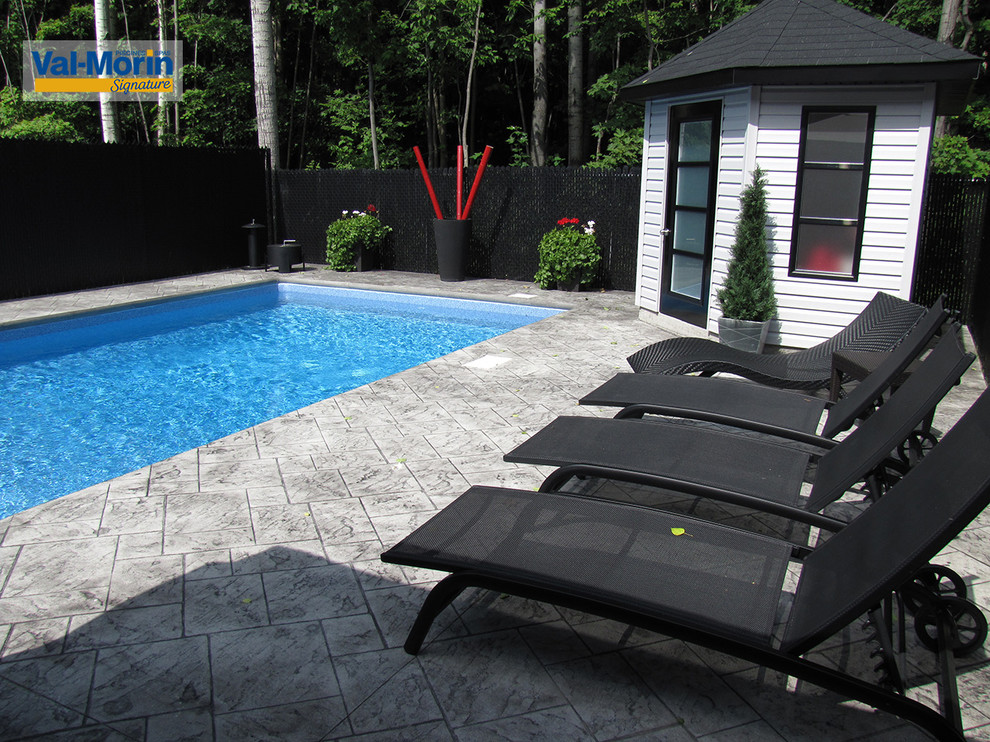 Mittelgroßer Moderner Pool hinter dem Haus in rechteckiger Form mit Betonplatten