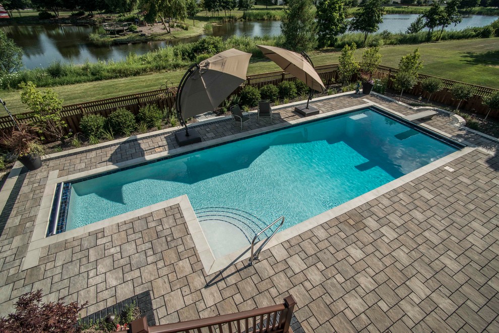 Pool - mid-sized traditional backyard concrete paver and l-shaped lap pool idea in Chicago