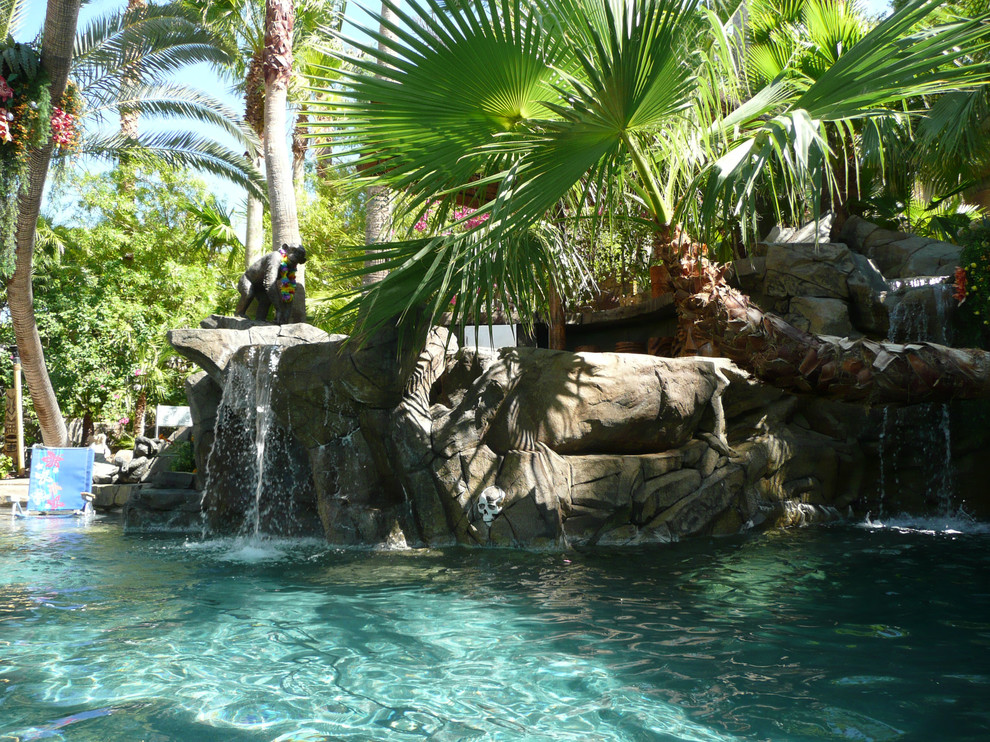 Inspiration för en tropisk anpassad baddamm på baksidan av huset, med en fontän
