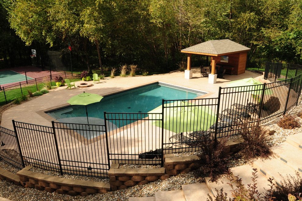 Источник вдохновения для домашнего уюта: большой прямоугольный бассейн на заднем дворе в классическом стиле с домиком у бассейна и покрытием из декоративного бетона