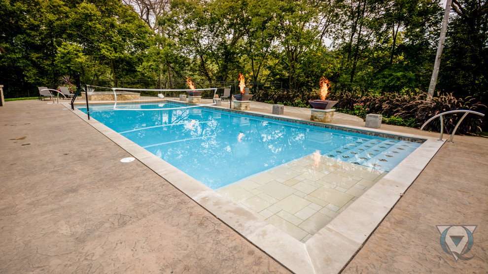 Foto di una piscina naturale classica rettangolare di medie dimensioni e dietro casa con fontane e cemento stampato
