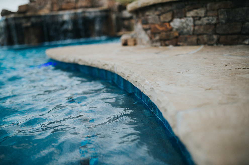 Idée de décoration pour une grande piscine arrière craftsman sur mesure avec un point d'eau et des pavés en pierre naturelle.