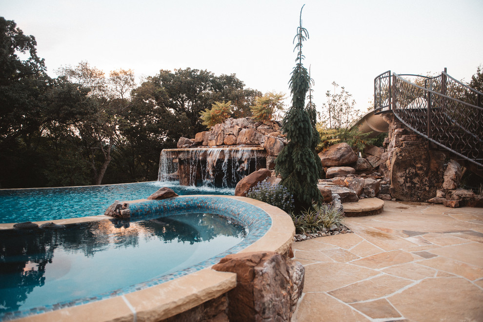 Esempio di una grande piscina stile americano personalizzata dietro casa con fontane