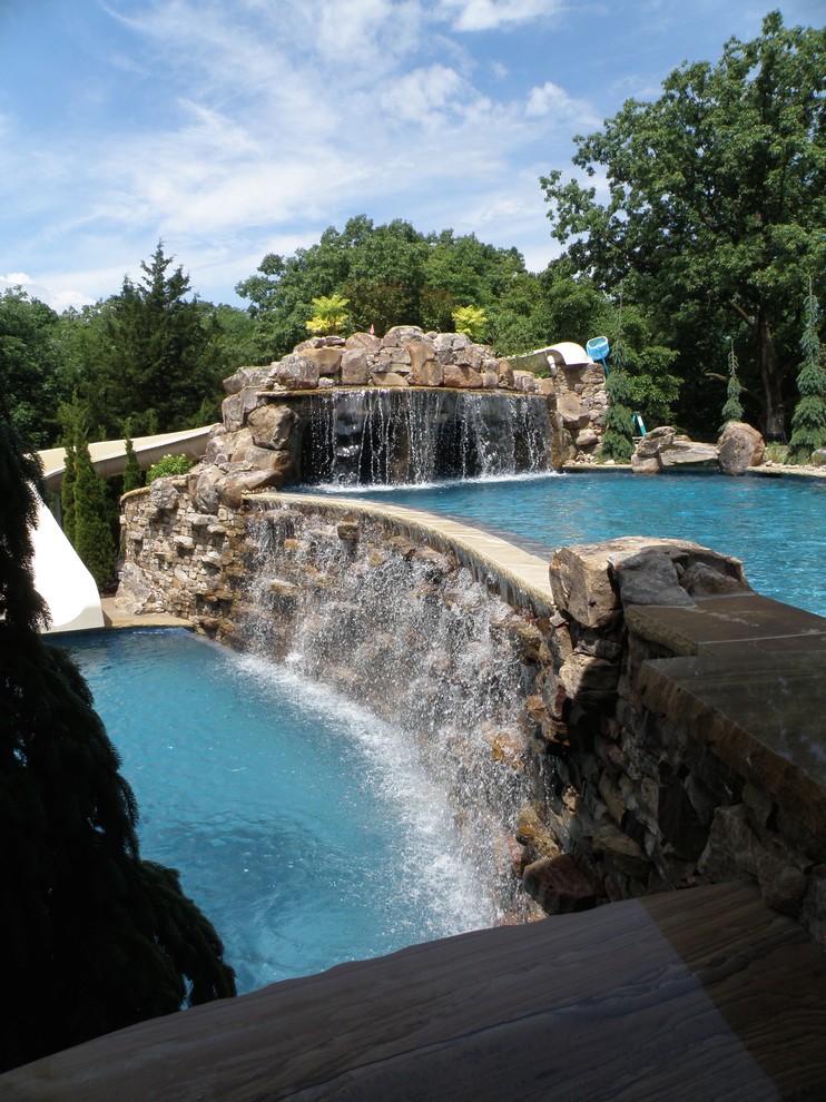 Inspiration for a medium sized traditional back custom shaped swimming pool in Kansas City with a water feature.
