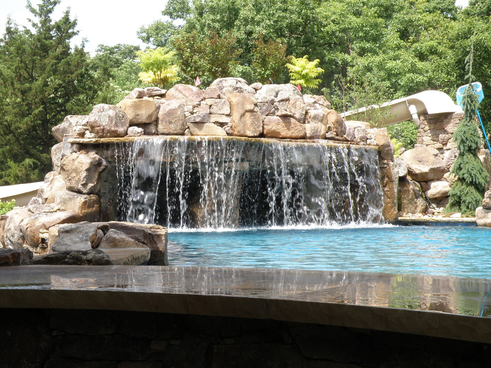 Aménagement d'une grande piscine arrière craftsman sur mesure avec un point d'eau.