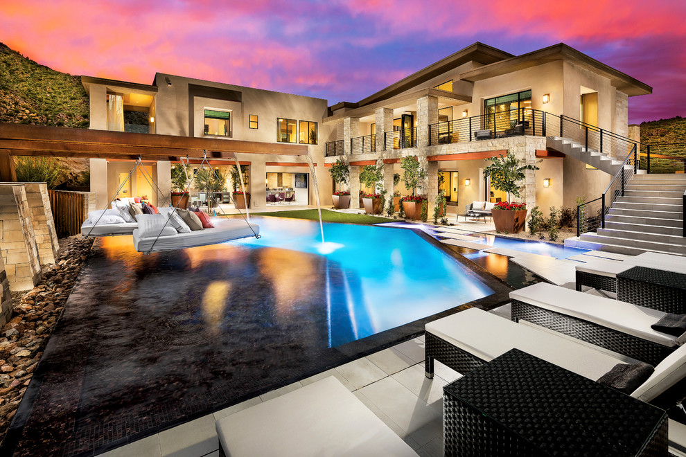 Example of a huge southwest backyard concrete paver and custom-shaped infinity pool fountain design in Phoenix