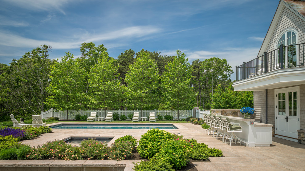 Diseño de piscina natural costera de tamaño medio rectangular en patio trasero con adoquines de piedra natural