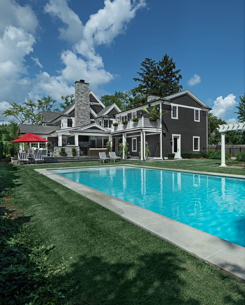 Идея дизайна: большой естественный, прямоугольный бассейн на заднем дворе в классическом стиле с домиком у бассейна и мощением клинкерной брусчаткой
