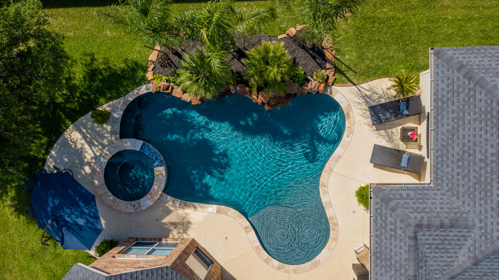 Foto de piscina tropical de tamaño medio a medida en patio trasero con entablado