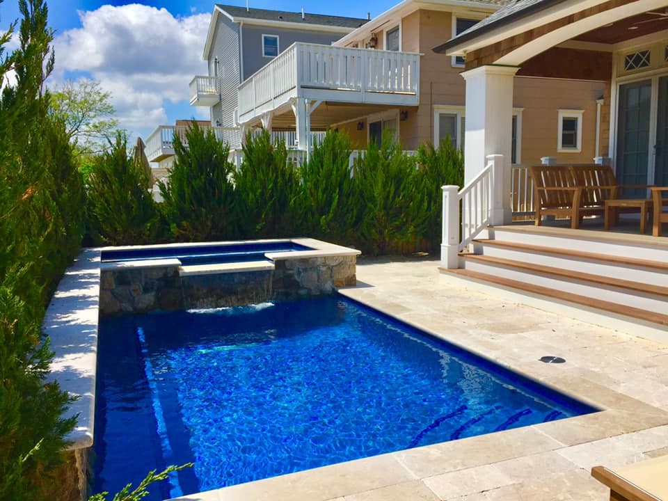Foto di una piccola piscina tradizionale rettangolare dietro casa con una vasca idromassaggio e pavimentazioni in pietra naturale