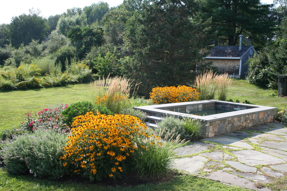 This is an example of a small classic back rectangular swimming pool in Boston with natural stone paving.