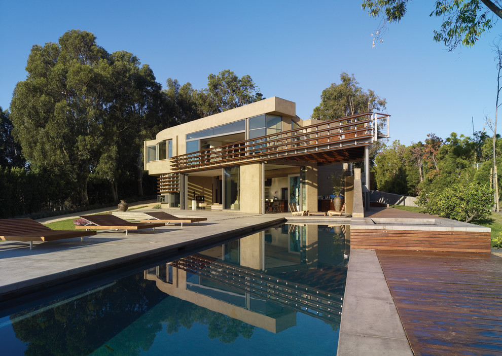 Imagen de piscina con fuente alargada moderna de tamaño medio rectangular en patio trasero con losas de hormigón