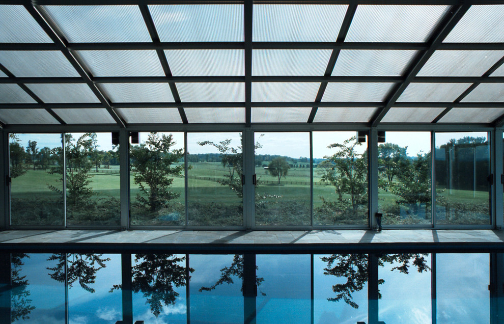 Exempel på en mellanstor modern rektangulär, inomhus pool, med poolhus och naturstensplattor