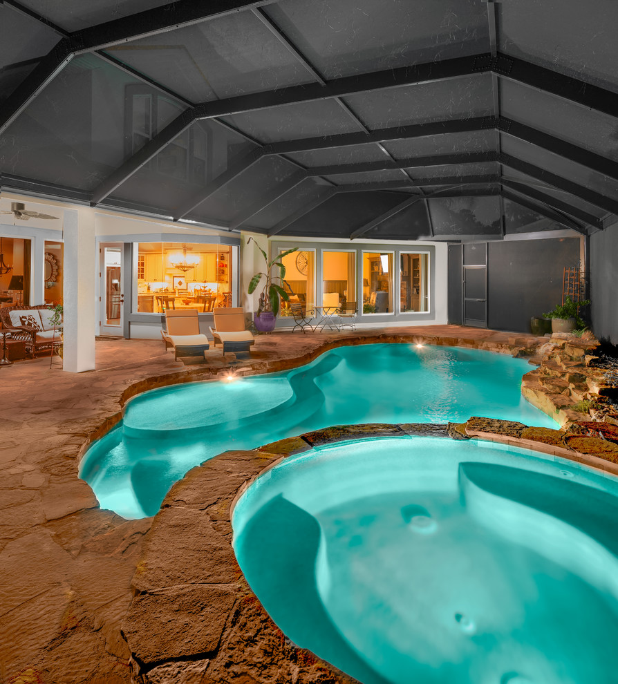 Cette photo montre une grande piscine naturelle et arrière exotique sur mesure avec un point d'eau et des pavés en pierre naturelle.