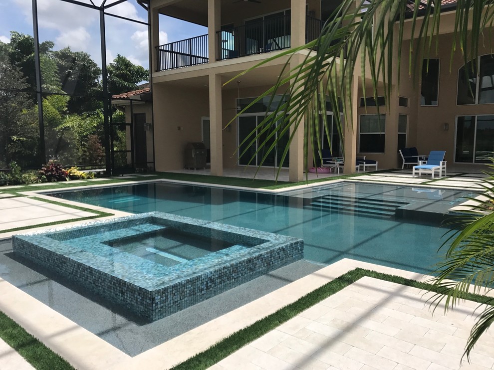 Modelo de piscinas y jacuzzis minimalistas grandes en patio trasero con adoquines de piedra natural