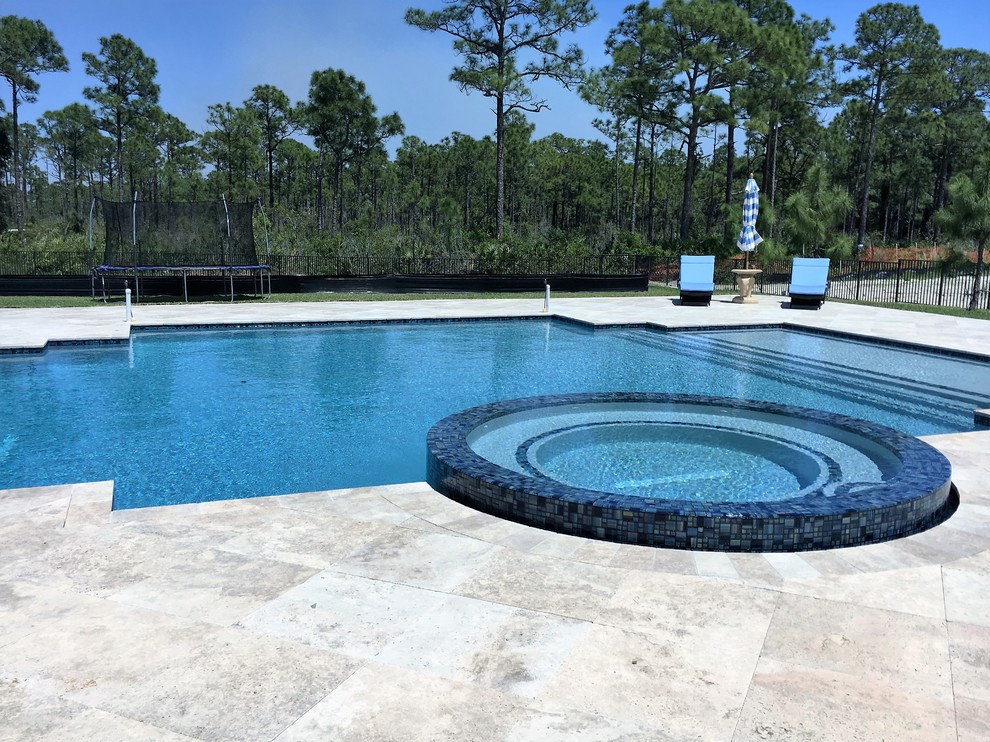 Modelo de piscinas y jacuzzis infinitos minimalistas grandes rectangulares en patio trasero con adoquines de piedra natural