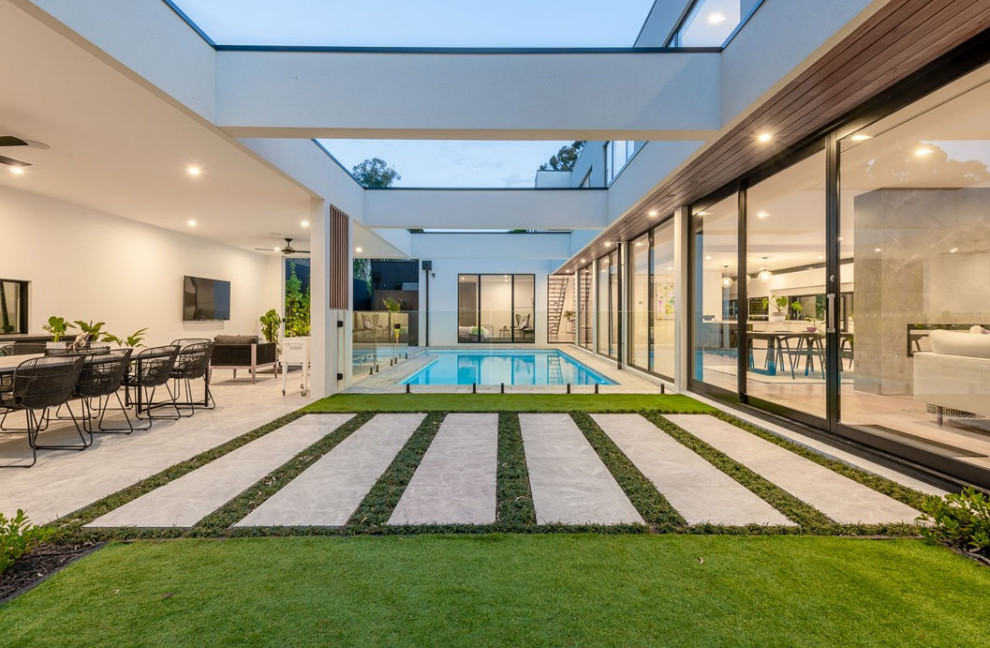 Стильный дизайн: маленький прямоугольный ландшафтный бассейн на внутреннем дворе в стиле модернизм с мощением тротуарной плиткой для на участке и в саду - последний тренд