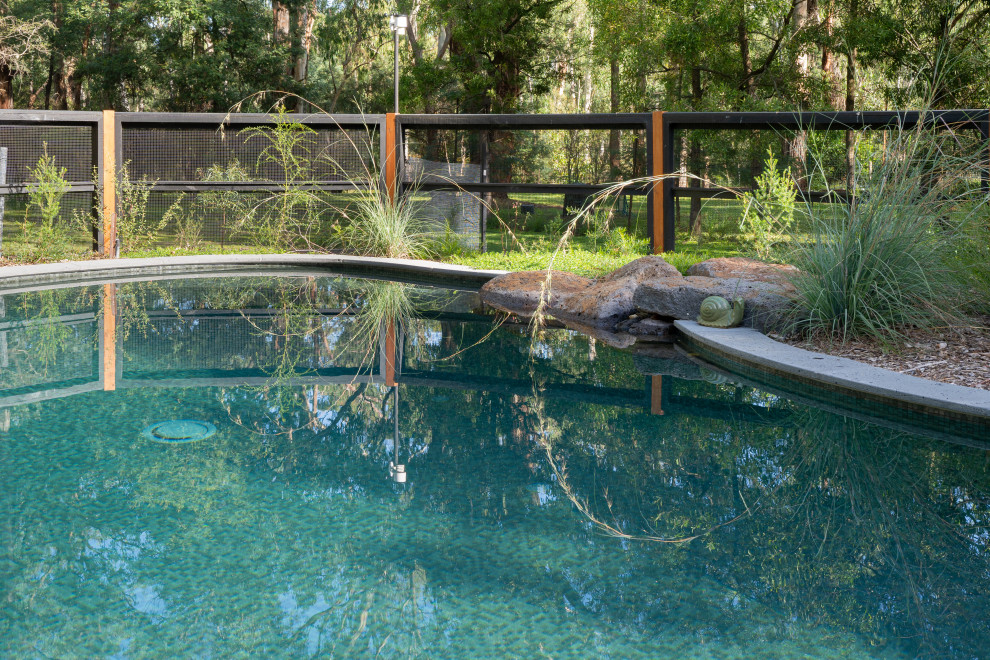 Großer Mediterraner Pool hinter dem Haus in individueller Form mit Natursteinplatten in Melbourne