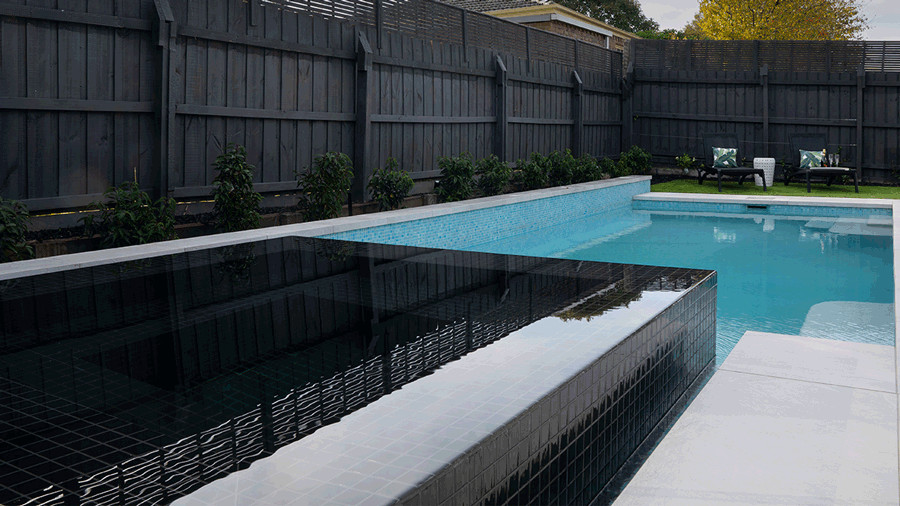 Idee per una grande piscina monocorsia moderna rettangolare dietro casa con una vasca idromassaggio e pavimentazioni in cemento