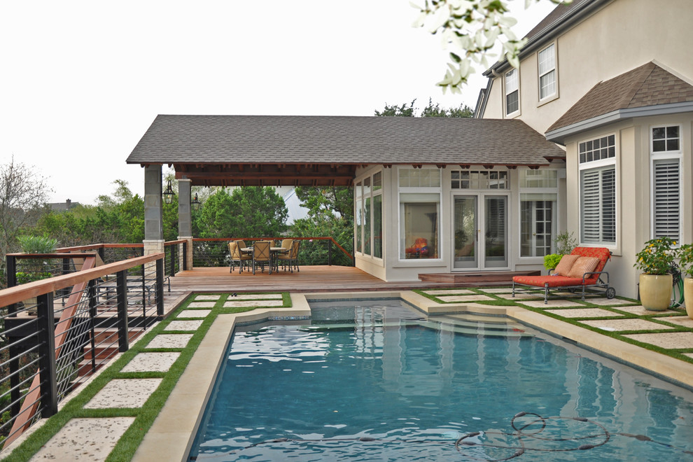 На фото: большой прямоугольный бассейн на заднем дворе в классическом стиле с мощением тротуарной плиткой с