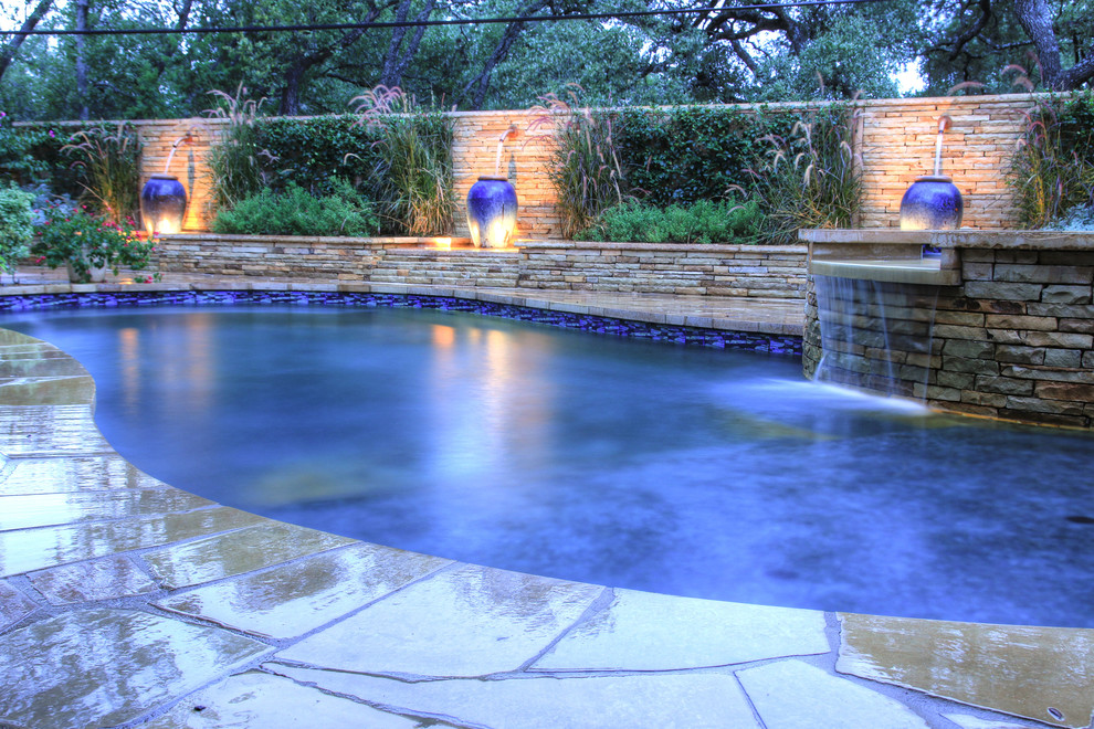 Medium sized mediterranean back kidney-shaped natural hot tub in Austin with natural stone paving.