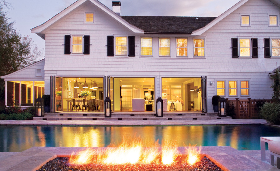 Imagen de casa de la piscina y piscina marinera extra grande rectangular en patio trasero con adoquines de piedra natural