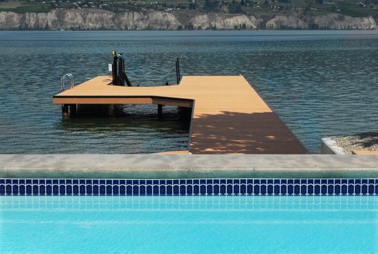 Réalisation d'une piscine arrière de taille moyenne et rectangle avec des pavés en béton.