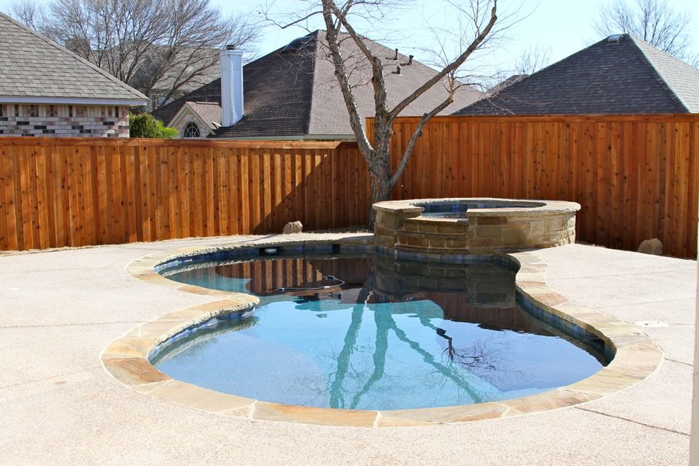 На фото: спортивный бассейн в форме фасоли, среднего размера на заднем дворе в классическом стиле с джакузи и покрытием из гранитной крошки с