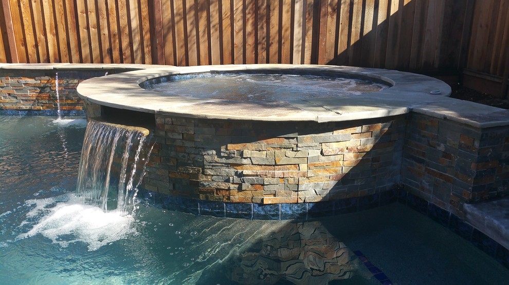 Ispirazione per una piscina tradizionale a "C" dietro casa e di medie dimensioni con cemento stampato e una vasca idromassaggio